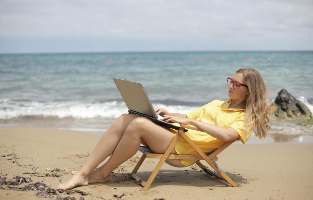 content submissions woman in yellow shirt sitting on brown wooden folding chair on beach