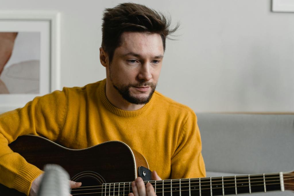 music a bearded man in yellow sweater playing guitar